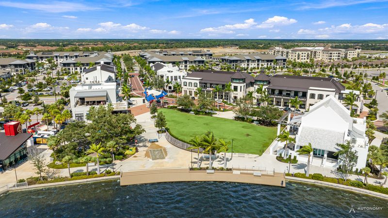 Daytime aerial of the Downtown Wellen lakefront lawn and buildings on the Grand Lake